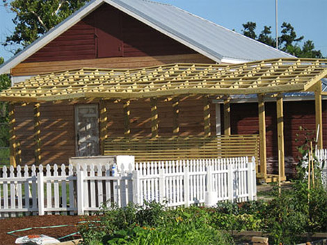 The rennovated porch for the Red House has a wooden trelis structure.